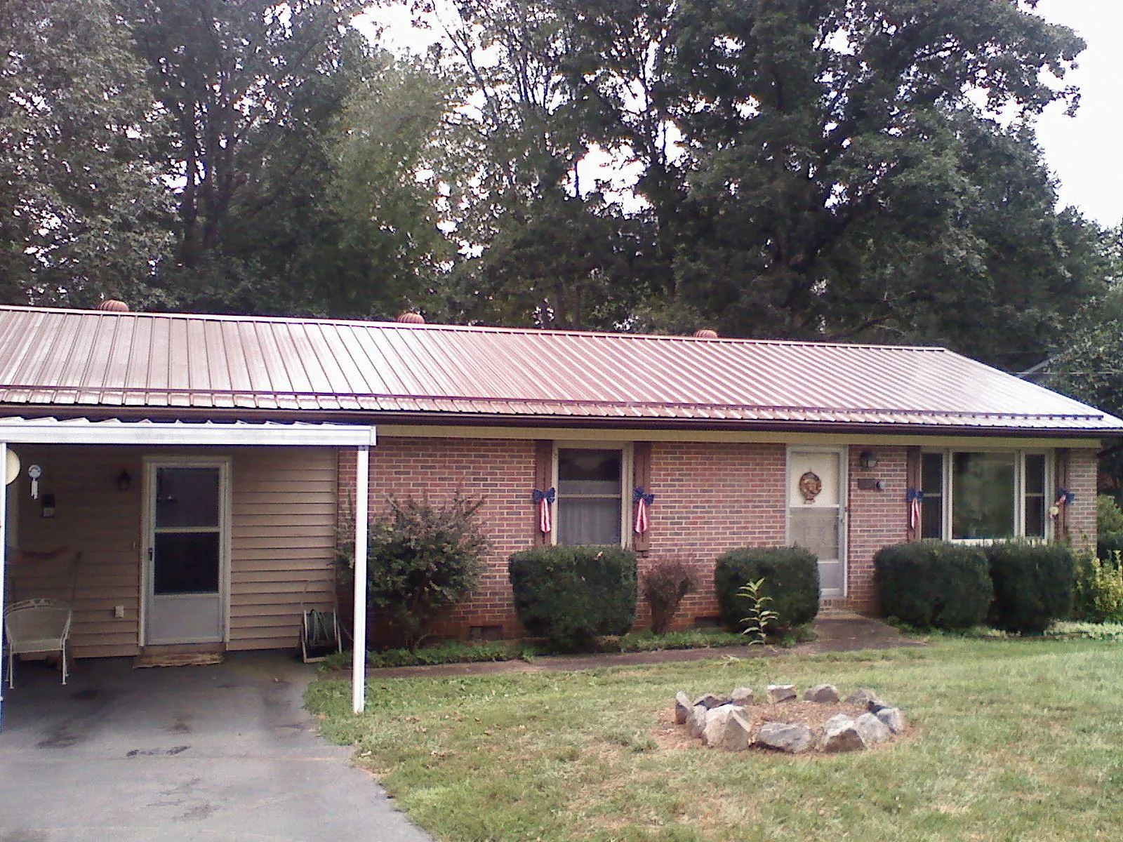 Bronze metal roof and carport on a brick ranch home — Roof Repair work by our crew in Petoskey